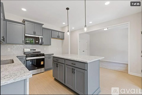 A kitchen with grey cabinets and a granite countertop.