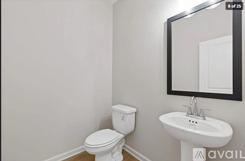 A white toilet and sink in a bathroom.