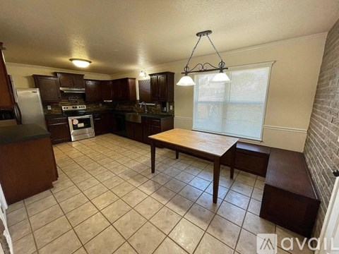 A kitchen with a table and chairs in the middle of the room.