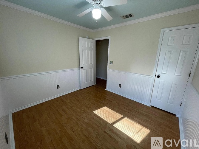 A room with a wooden floor and a ceiling fan.