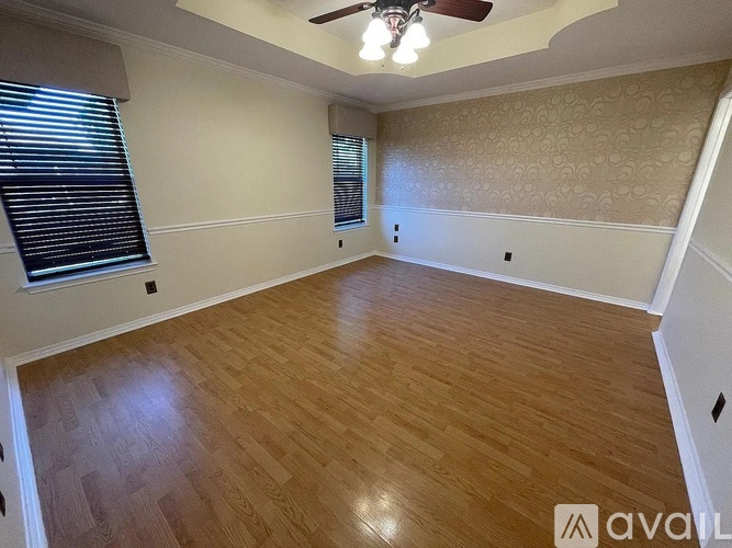 A room with wooden flooring and a ceiling fan.