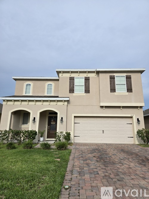 A two-story house with a garage and a brick pathway leading to the front door.