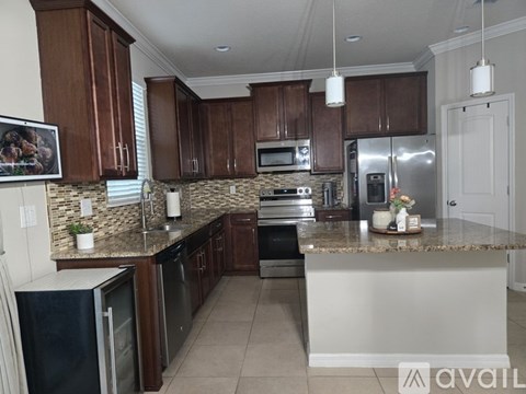 A kitchen with brown cabinets and a granite countertop.