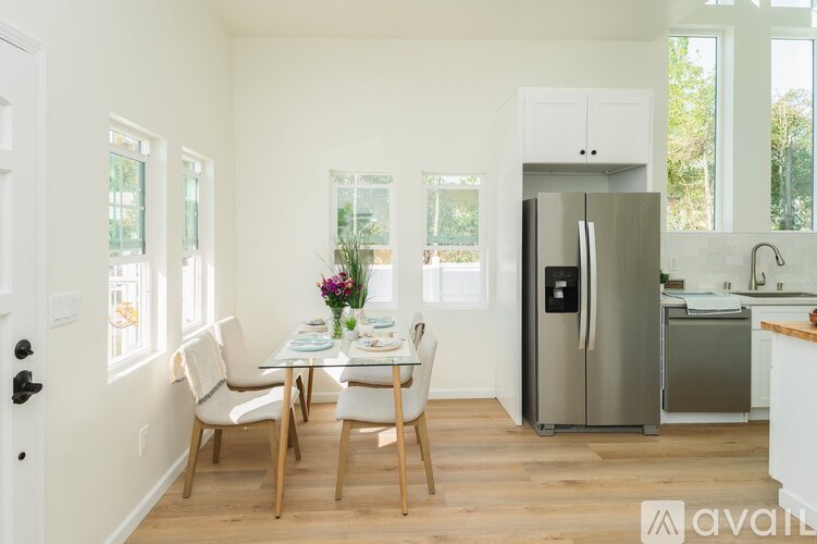 A kitchen with a dining table set up with chairs.