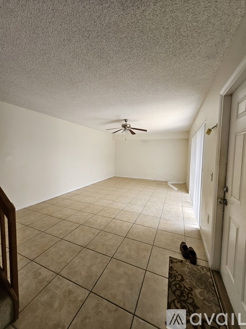 A room with a ceiling fan and a door.