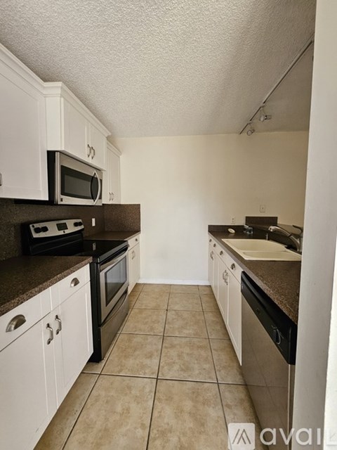 A kitchen with white cabinets and brown countertops.