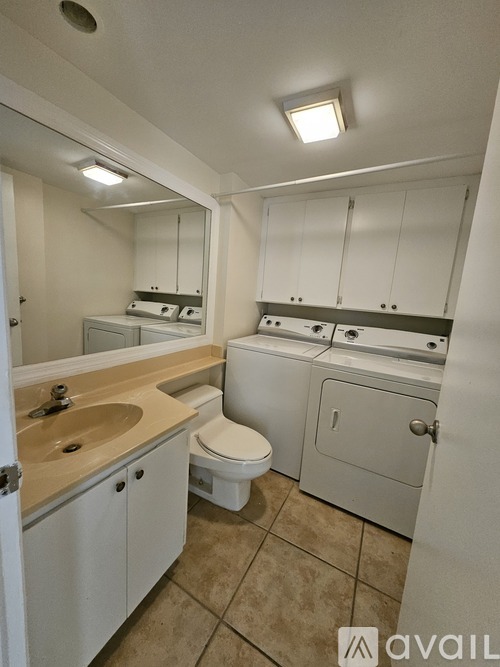 A bathroom with a toilet, sink, and mirror.