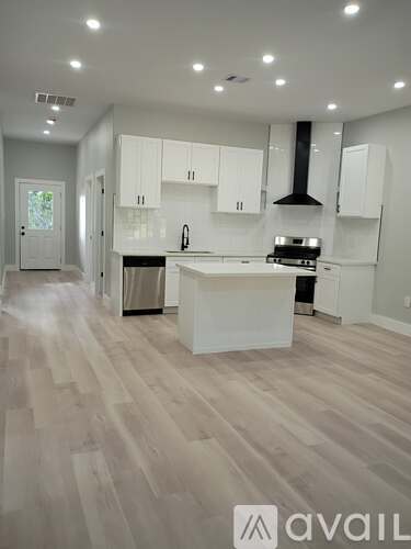 A kitchen with white cabinets and a large island.