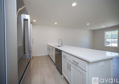 A modern kitchen with white cabinets and a stainless steel refrigerator.