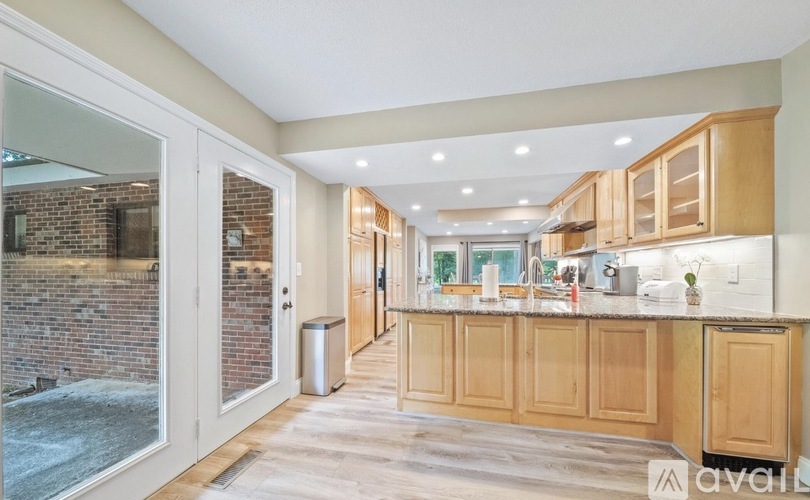 A kitchen with wooden cabinets and a brick wall.