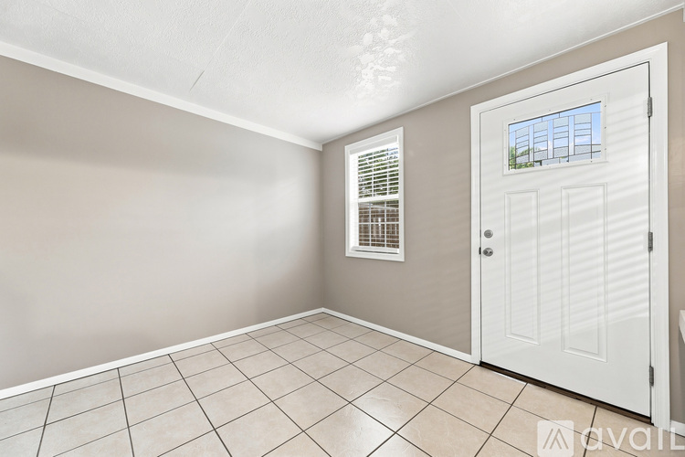 A room with a white door and a window with blinds.