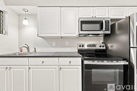A kitchen with white cabinets and appliances.