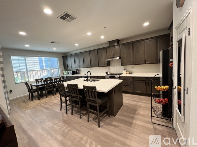 A modern kitchen with dark wood cabinets and a central island.
