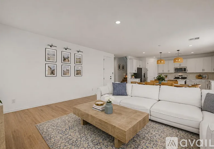 A living room with a white couch and pictures on the wall.