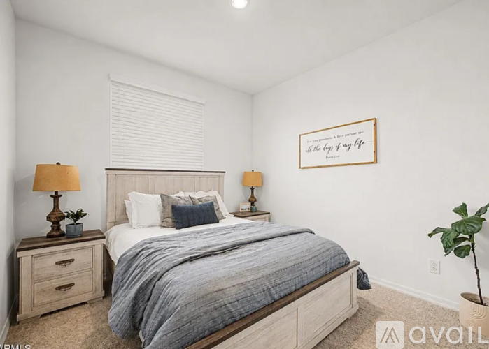 A bedroom with a bed, nightstands, and a framed picture on the wall.
