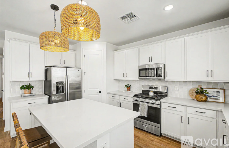 A kitchen with white cabinets and a large island.