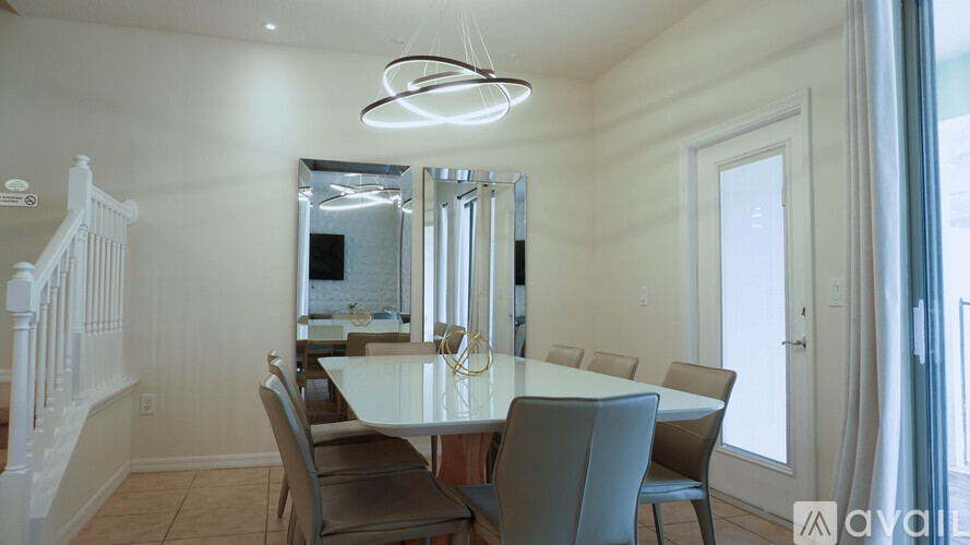 A dining room with a white table and chairs.