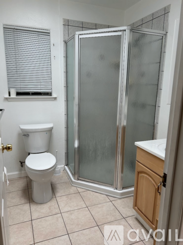 A bathroom with a toilet, sink, and shower.