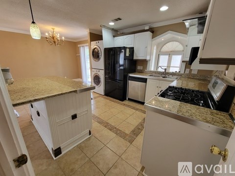 A kitchen with a granite countertop and a chandelier.