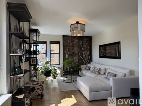 A living room with a white couch and a chandelier.