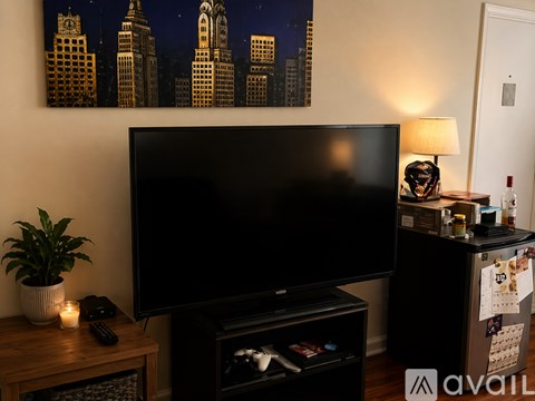 A black television set in a living room with a plant on the table.