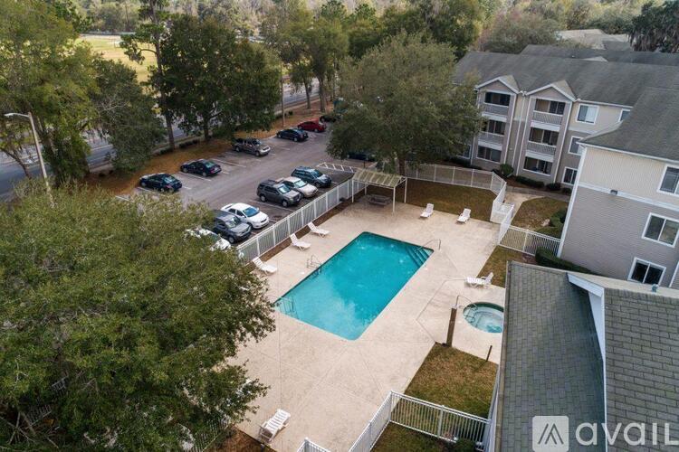 A bird's eye view of a pool surrounded by a fence and a building.
