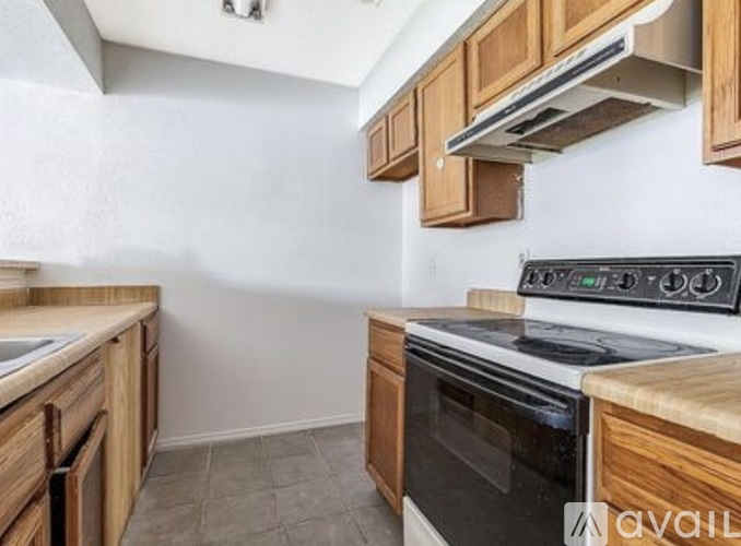 A kitchen with wooden cabinets and a black oven.