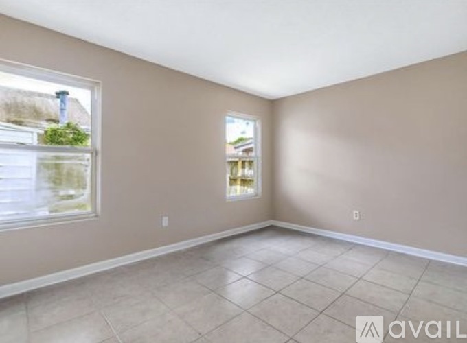 A room with a tiled floor and a window showing a view of a house.