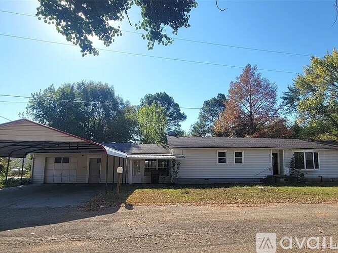 A house with a garage is surrounded by trees.