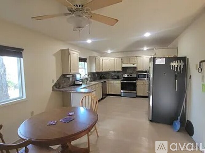 A kitchen with a table and chairs in front of it.