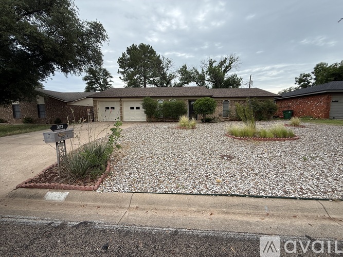 A gravel driveway leads to a house with a garage.