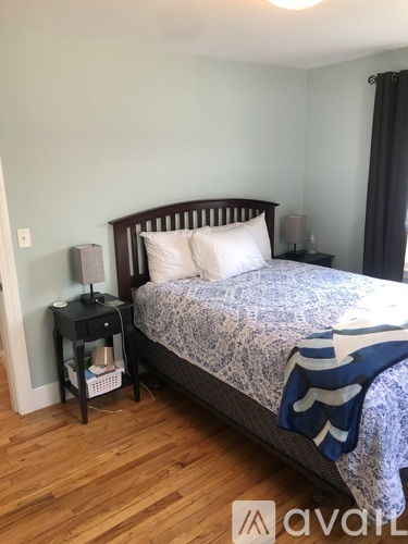 A bedroom with a bed, nightstand, and lamp.