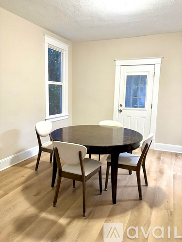 A dining room with a round table and chairs.