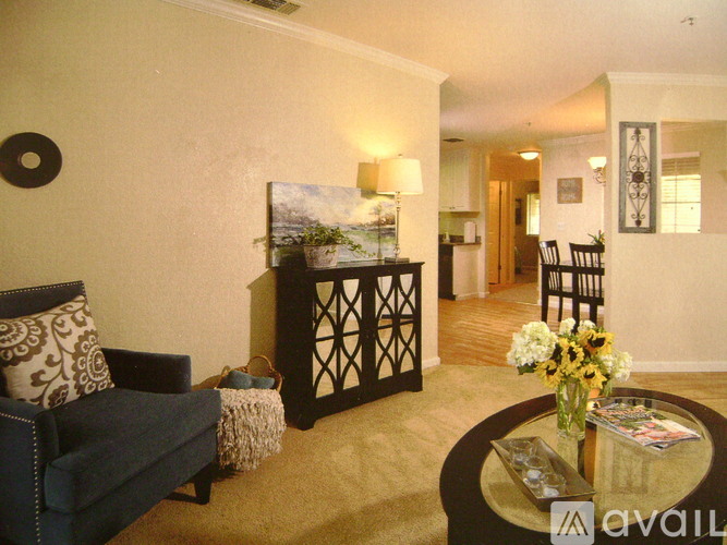 A living room with a couch, a coffee table, and a painting on the wall.