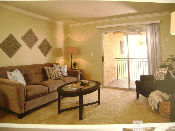 A living room with a brown couch, a coffee table, and a lamp.