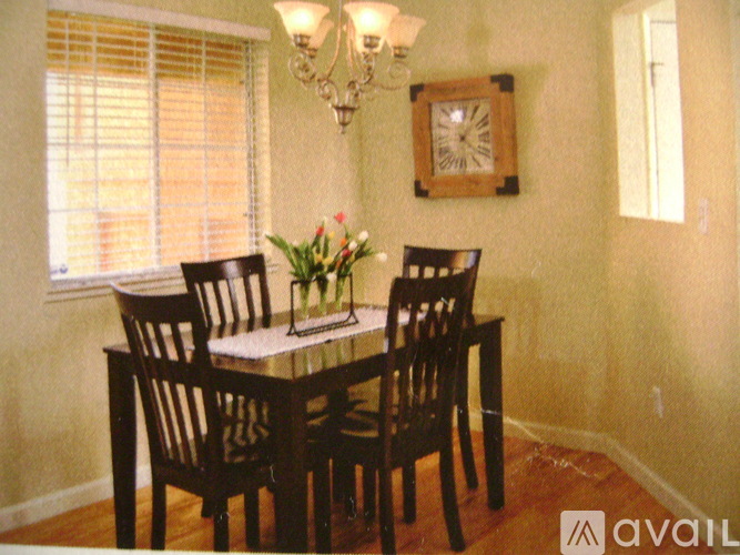 A dining room with a table set for four.