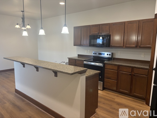 A kitchen with a granite countertop and wooden cabinets.