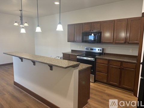 A kitchen with a granite countertop and wooden cabinets.