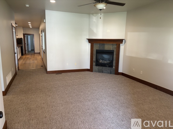 A living room with a fireplace and a carpeted floor.
