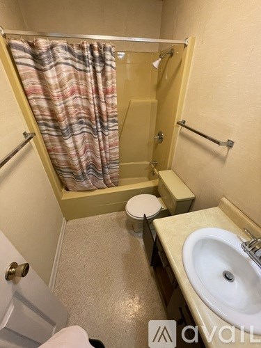 A bathroom with a toilet, sink, and shower.