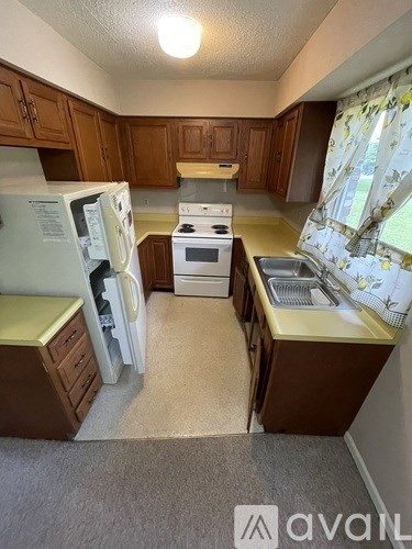 A small kitchen with a white fridge and a white stove.