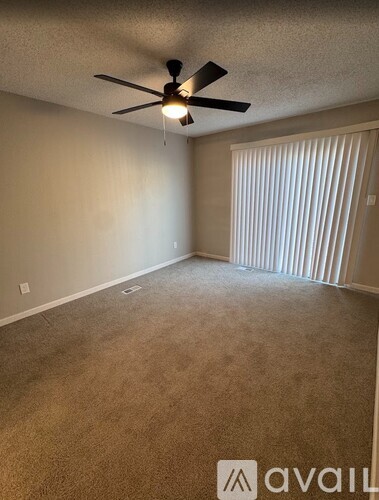 A living room with a fireplace and a ceiling fan.