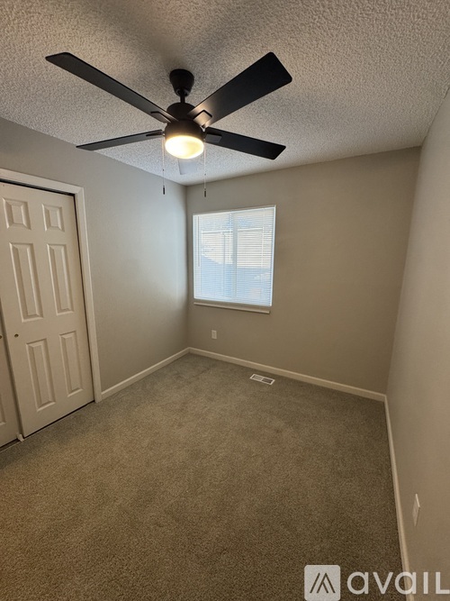 A room with a ceiling fan and a window.
