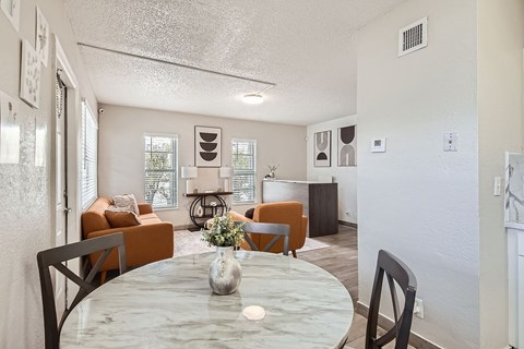 A dining room with a table and chairs.