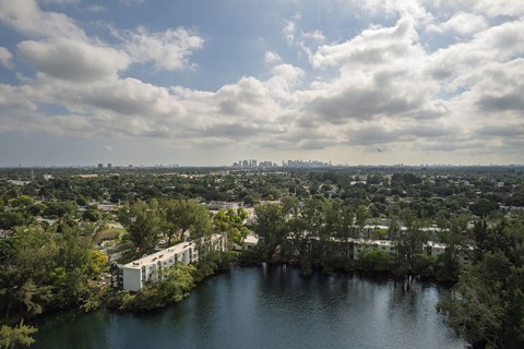A large body of water surrounded by trees and buildings.