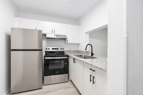 A modern kitchen with a stainless steel refrigerator and oven.