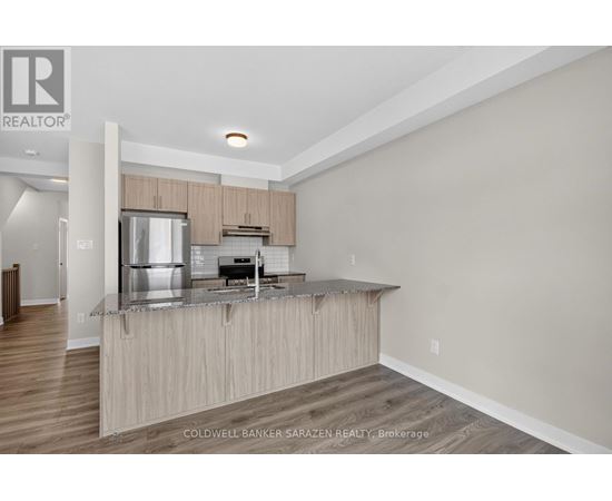 A modern kitchen with wooden cabinets and a stainless steel refrigerator.