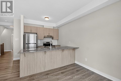 A modern kitchen with wooden cabinets and a stainless steel refrigerator.
