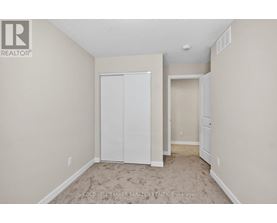 A bedroom with a white closet and carpeted floor.