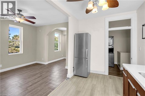 A kitchen with a refrigerator and a ceiling fan.